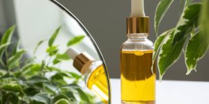 Frasco de óleo em cima de uma mesa com plantas e um espelho